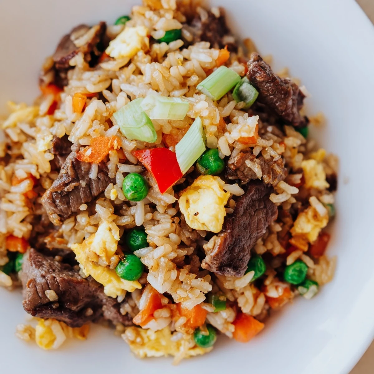 A generous serving of Beef Fried Rice with crisp veggies and tender beef ready to eat.