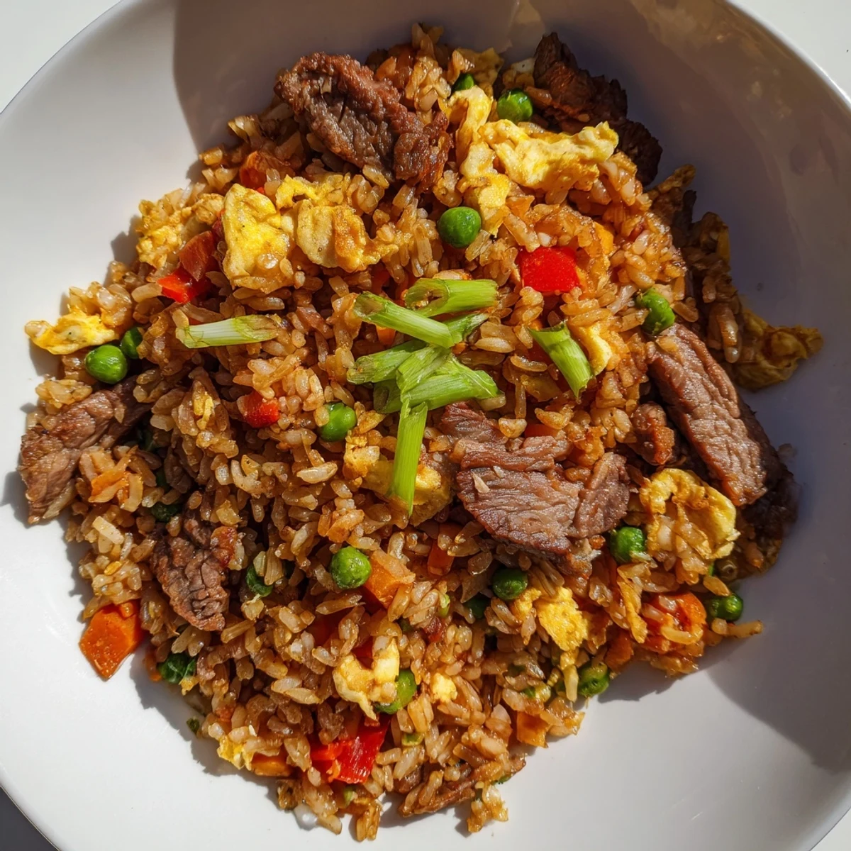 Colorful Beef Fried Rice featuring juicy beef, peas, carrots, and egg, served for a quick dinner.