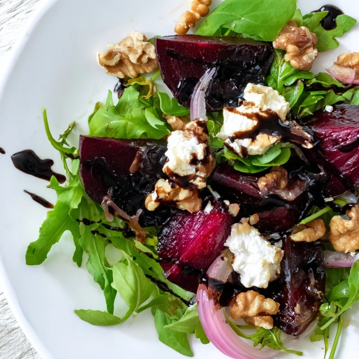 Freshly roasted beets, red onion slices, and goat cheese create a colorful Roasted Beet Salad with Goat Cheese Crumbles ready to enjoy.
